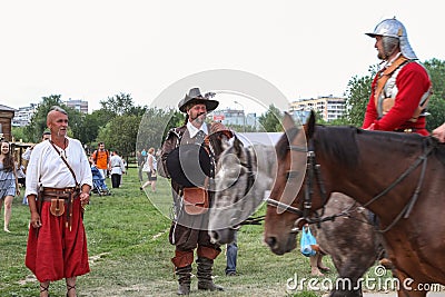 Cossack and musketeer looks at the passing knights on horseback Editorial Stock Photo